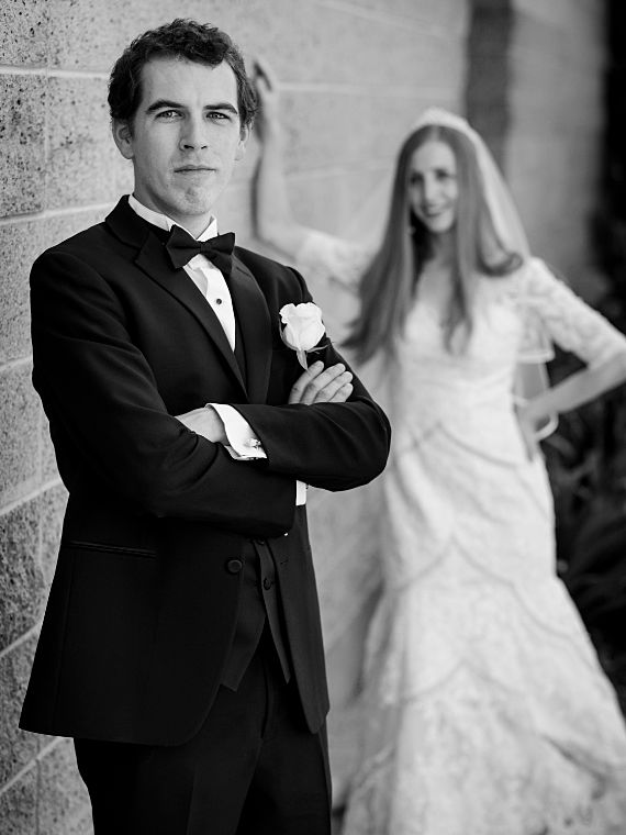 Bräutigam mit Braut unscharf im Hintergrund