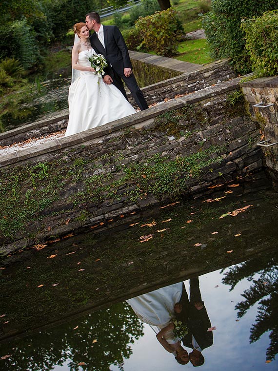 Brautpaar spiegelt sich im Wasser