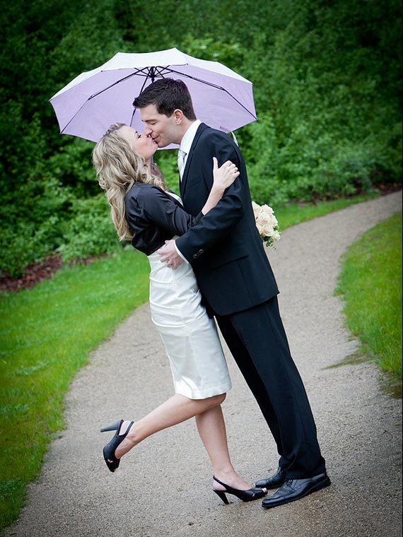 Hochzeitspaar Kuss unter Schirm