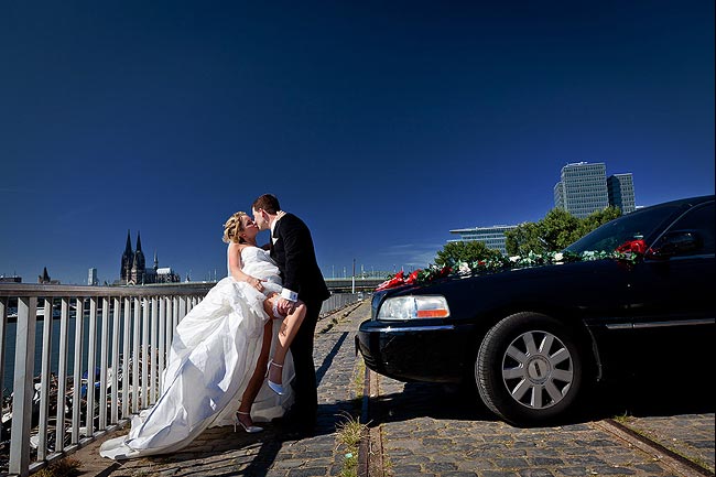 Brautpaar am Rhein mit Dom und Stretch-Limo